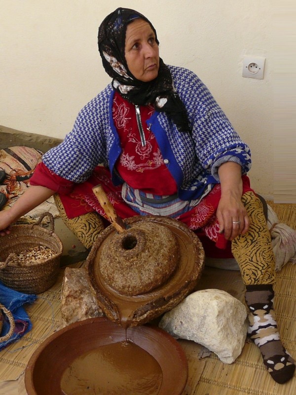 Eine Frau beim Mahlen mit der Arganöl-Mühle